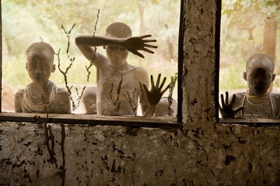 Children from the Kara tribe look through windows, Omo Valley, Ethiopia, 2013